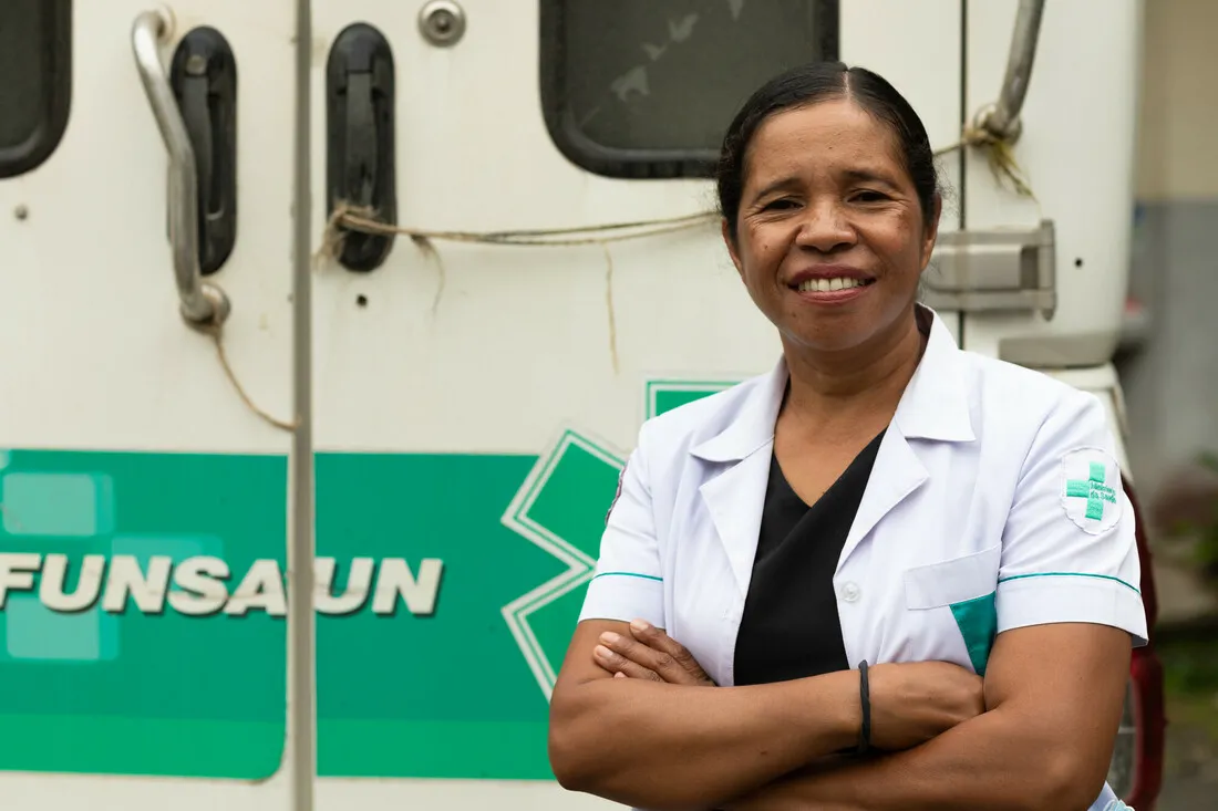A healthcare worker smiling and crossing her arms.