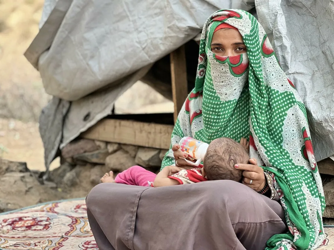 A woman feeding a baby with a bottle.