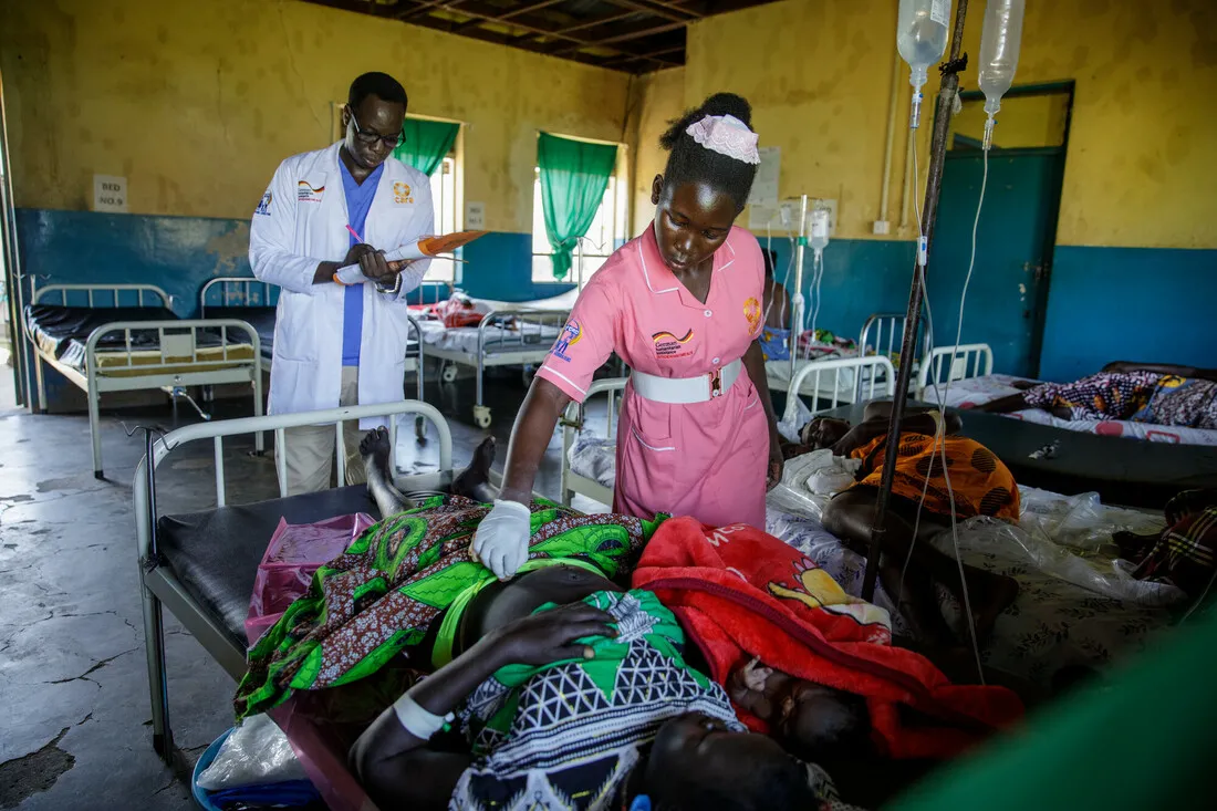 A woman and man in healthcare taking care of a patient.