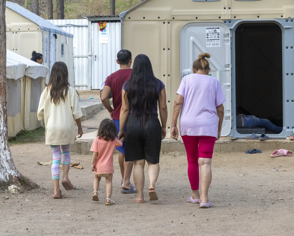 A family walks together through a makeshift shelter in Honduras.