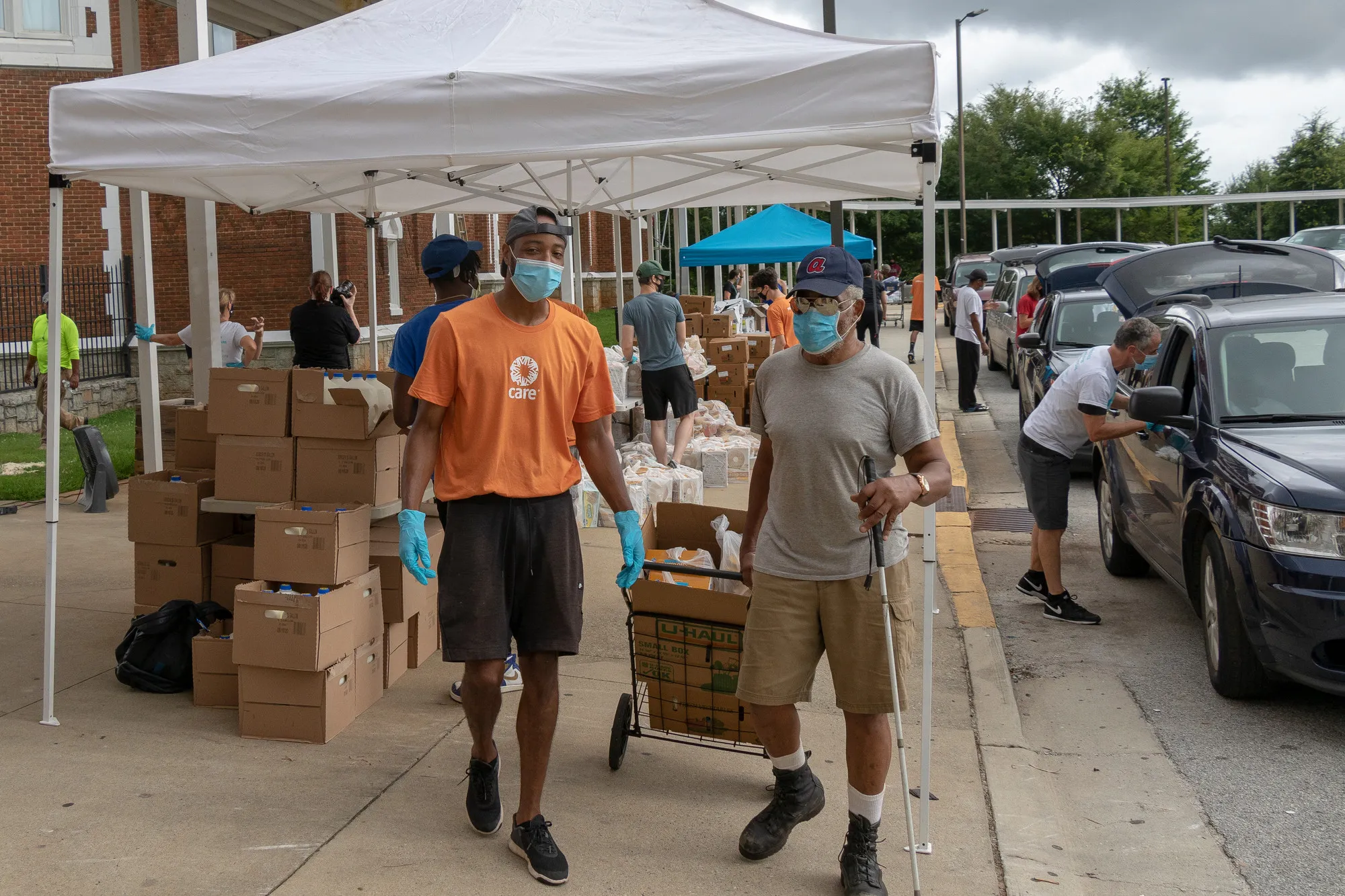 A CARE contractor walks with a man who has received groceries.