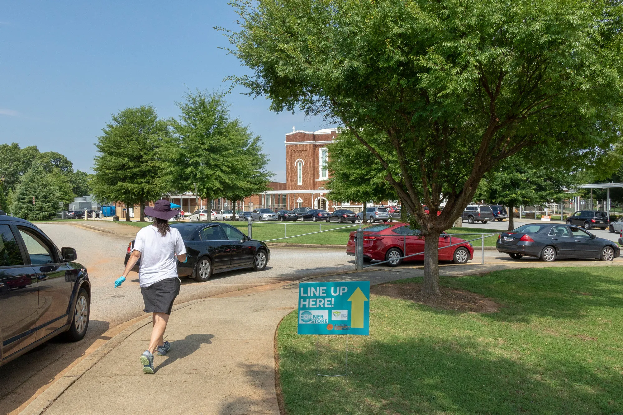 Cars line up in the driveway of a high school.