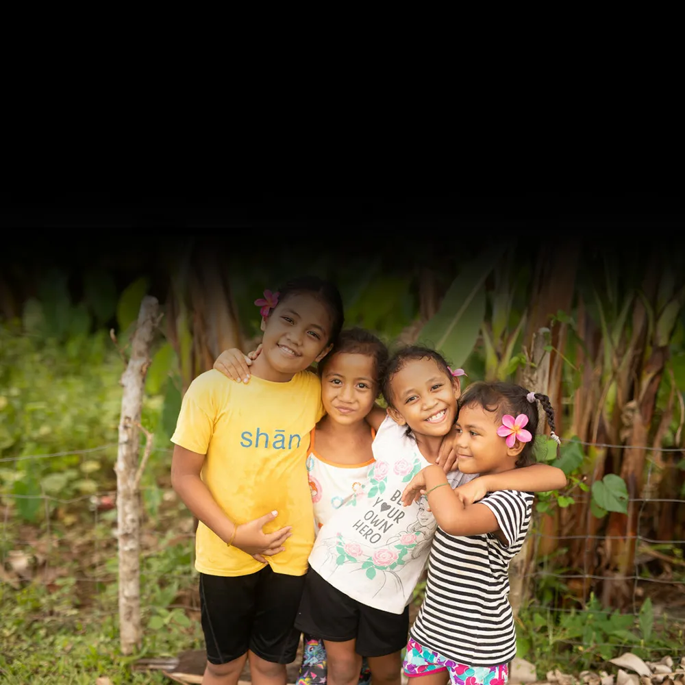 A group of girls smile and hug each other.